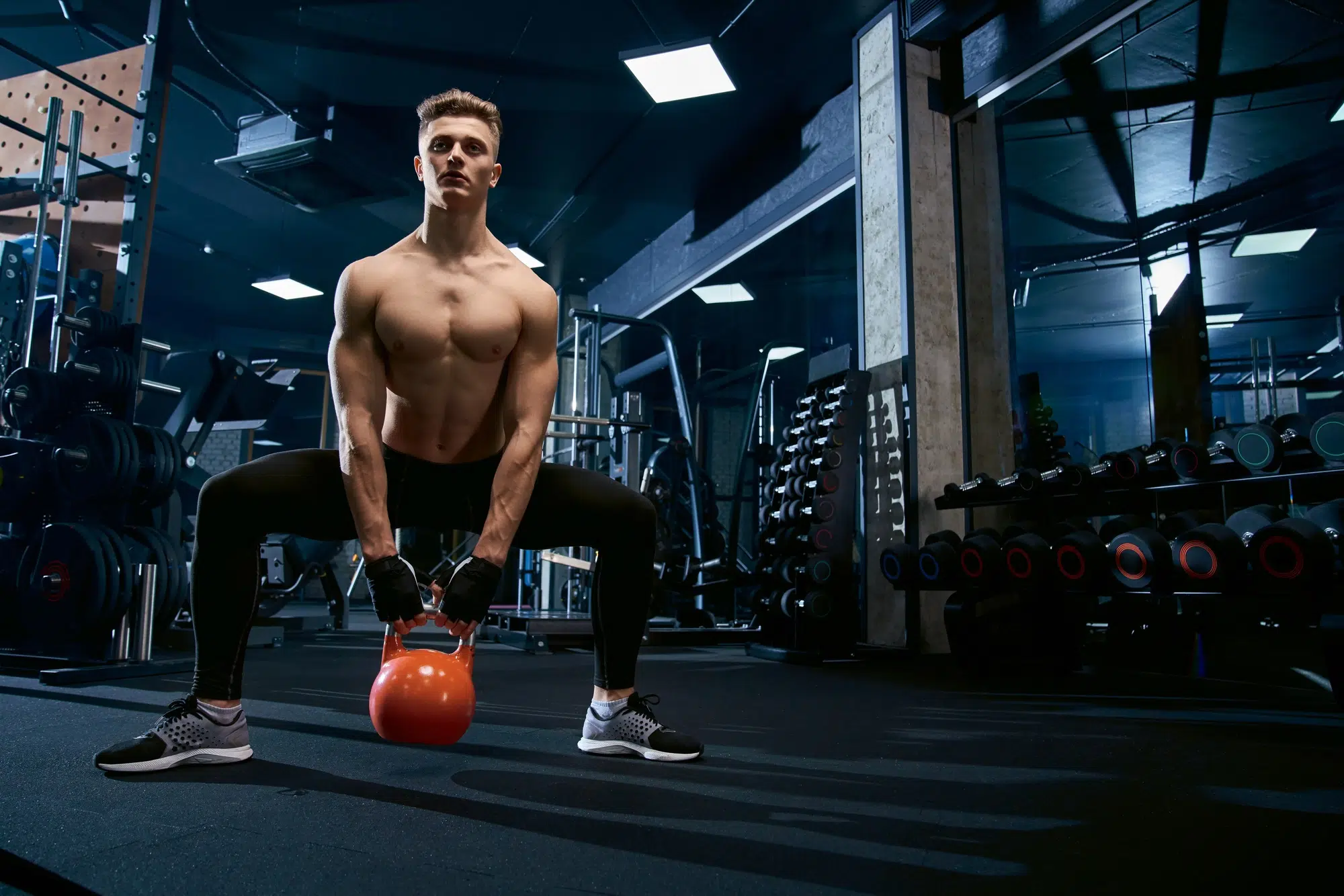 Sportsman doing plie squats with weights